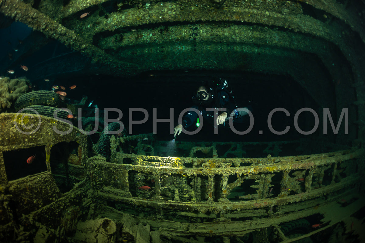 A diver- equipped with a rebreather- navigates the interior of a shipwreck in the Red Sea.