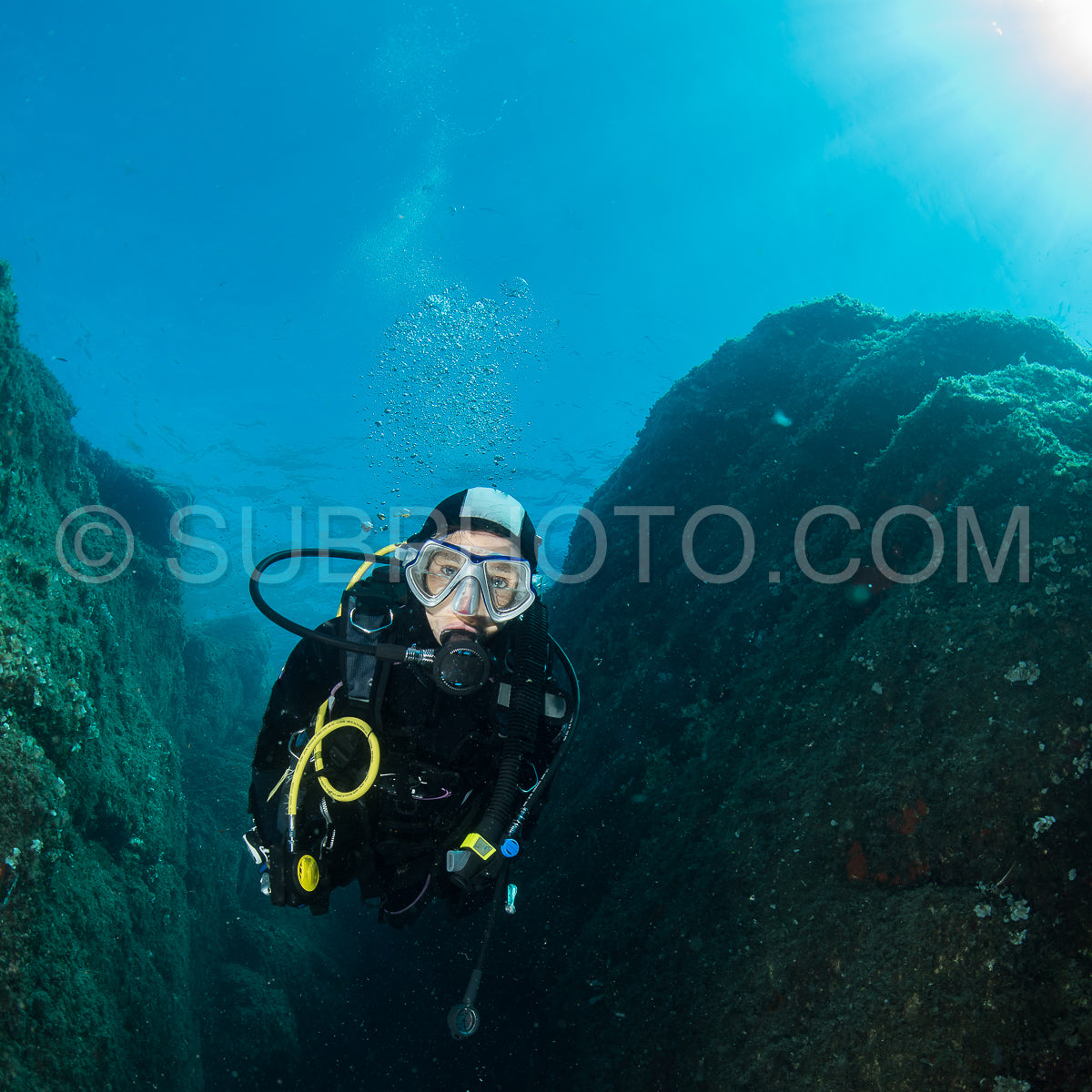 woman scuba diving over rocks in the Mediterranean Sea