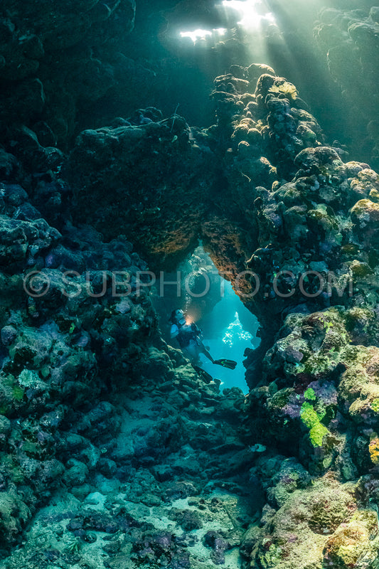 Photo de Femme plongeuse visitant une grotte sous-marine dans la mer rouge - Égypte - Shaab Claude