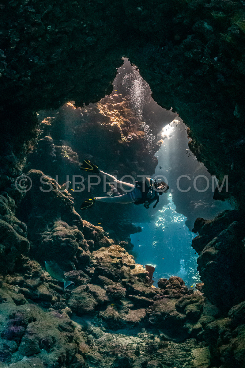 Photo de Femme plongeuse visitant une grotte sous-marine dans la mer rouge - Égypte - Shaab Claude