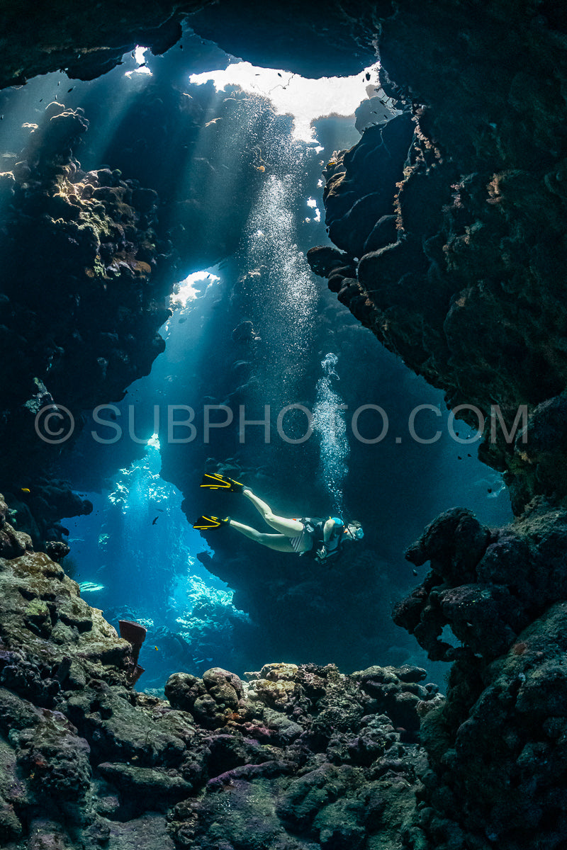 Photo de Femme plongeuse visitant une grotte sous-marine dans la mer rouge - Égypte - Shaab Claude