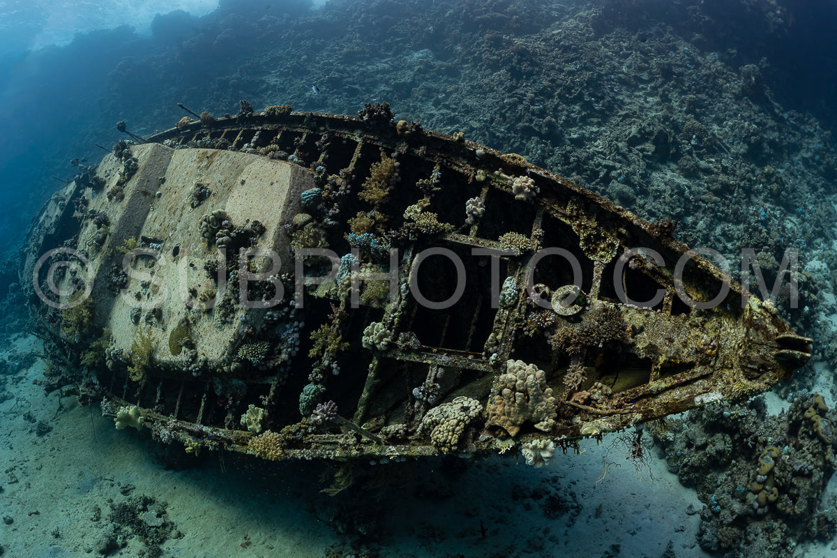 divers visiting an underwater wreck of a metal sailboat on a reef in the Rea Sea- Egypt