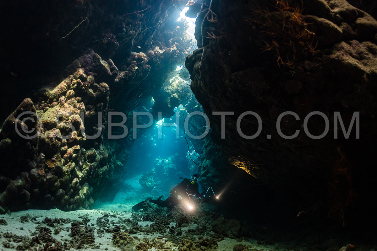 Photo de grotte sous-marine typique dans un récif de mer rouge avec un plongeur photographe sous-marin