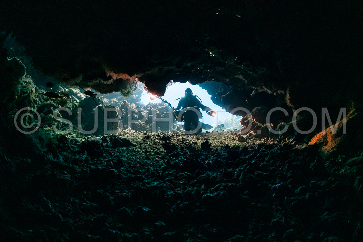 Photo de grotte sous-marine typique dans un récif de mer rouge avec un plongeur photographe sous-marin