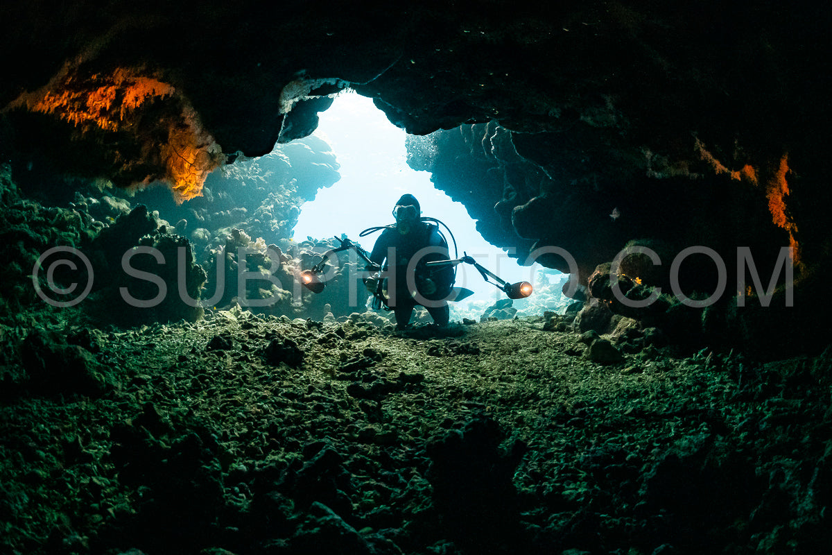 Photo de grotte sous-marine typique dans un récif de mer rouge avec un plongeur photographe sous-marin