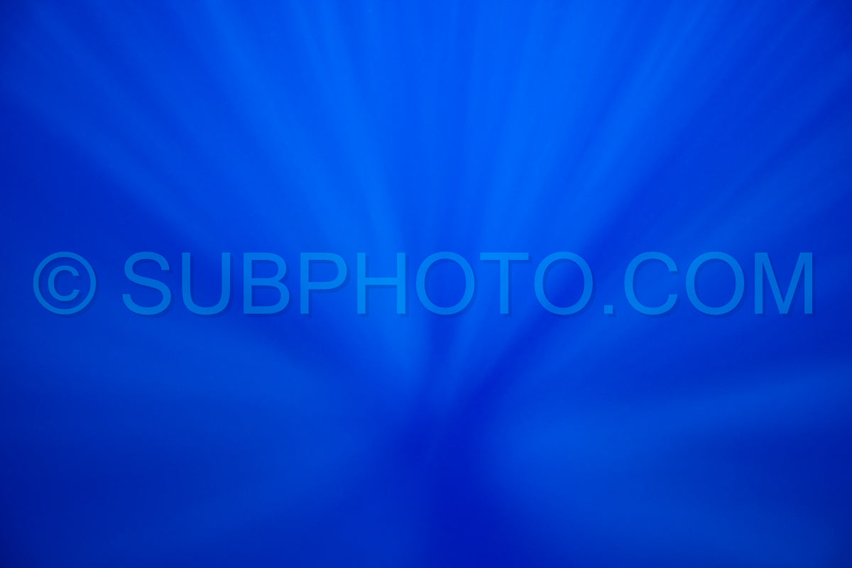 looking down underwater in a deep ocean under sunlight