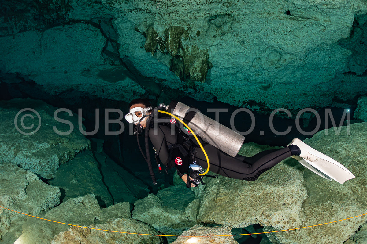 cave diver instructor leading a group of divers in a mexican cenote underwater