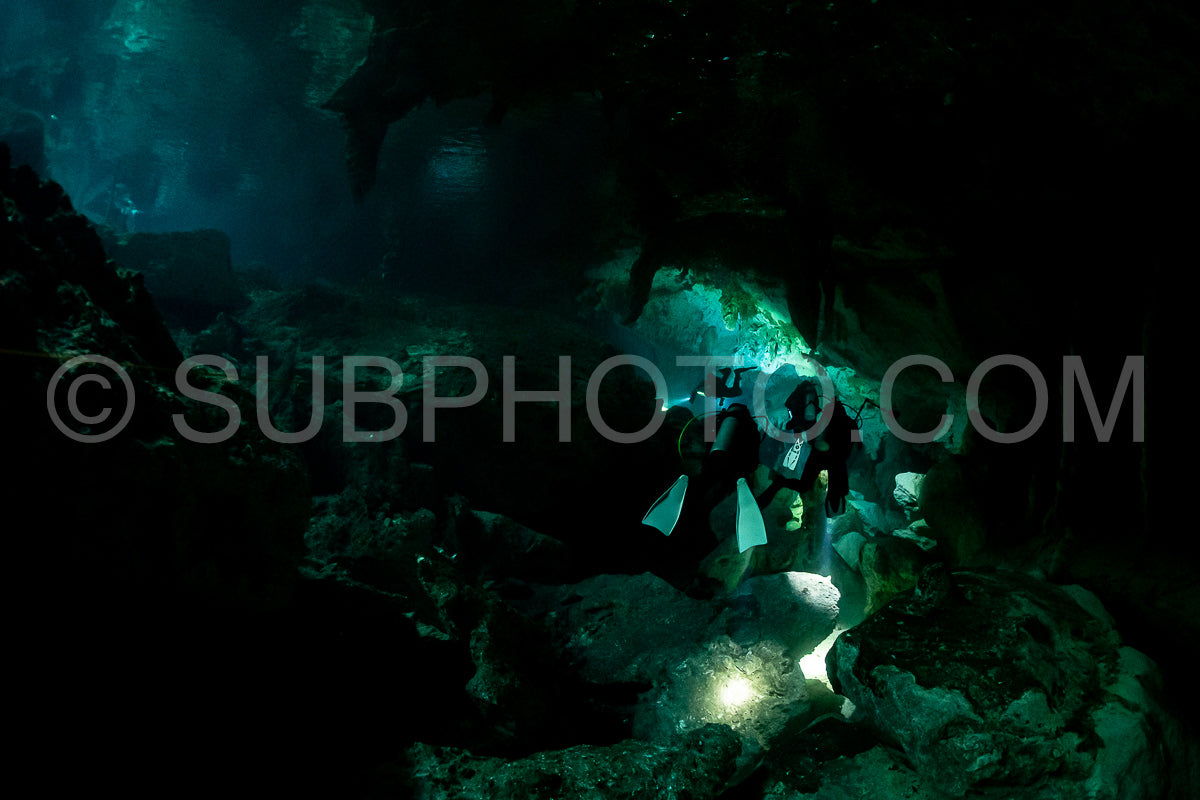 Photo de instructeur de plongée spéléo dirigeant un groupe de plongeurs dans un cenote mexicain sous l'eau