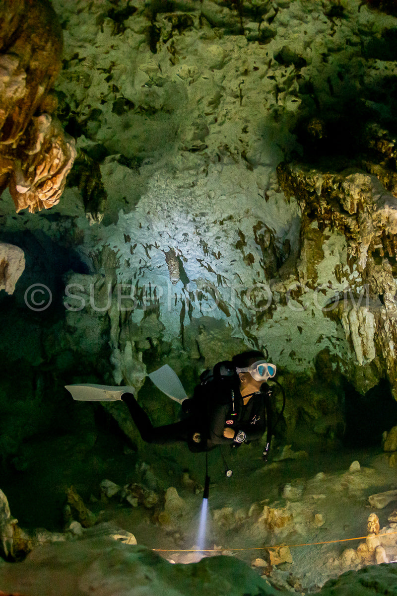 cave diver instructor leading a group of divers in a mexican cenote underwater
