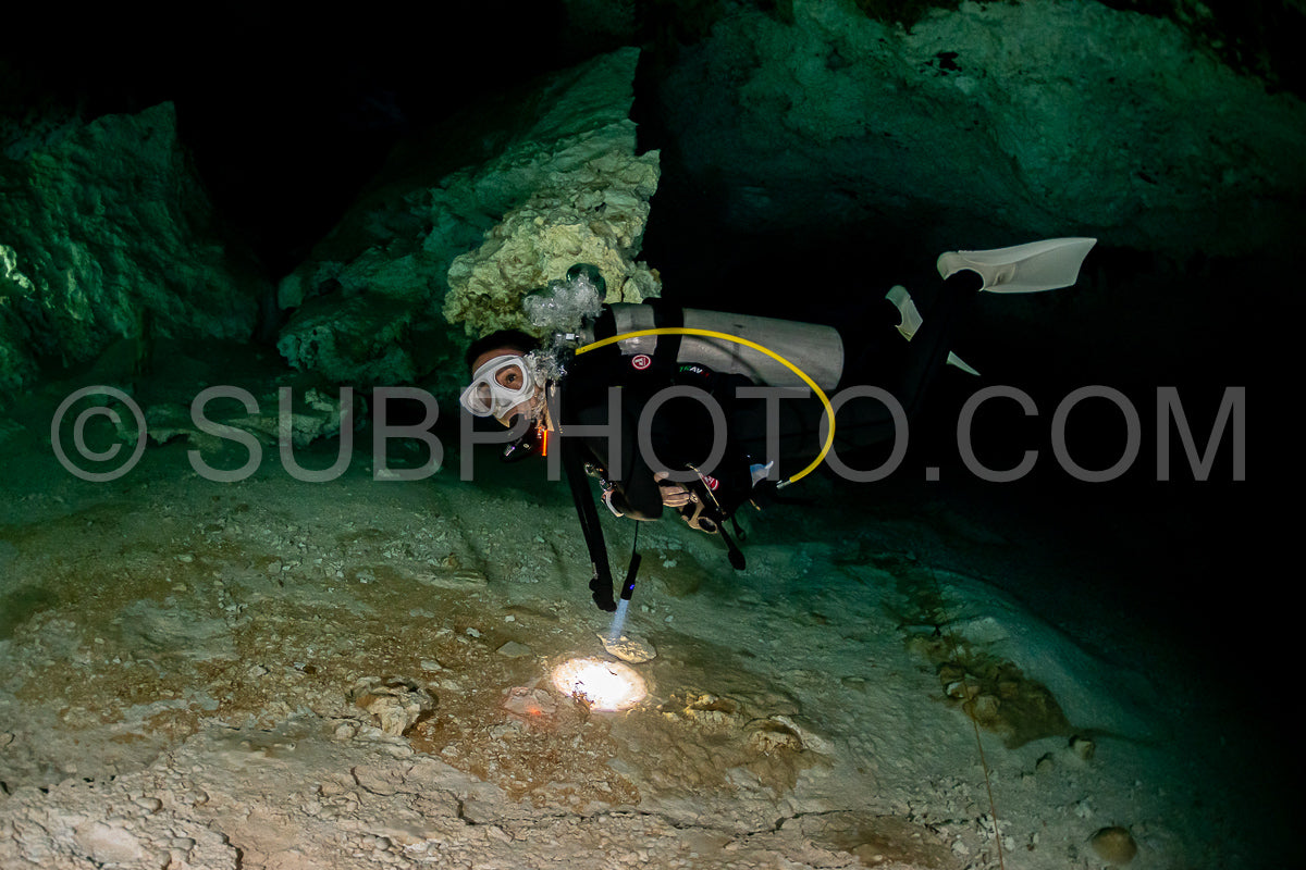 Photo de instructeur de plongée spéléo dirigeant un groupe de plongeurs dans un cenote mexicain sous l'eau