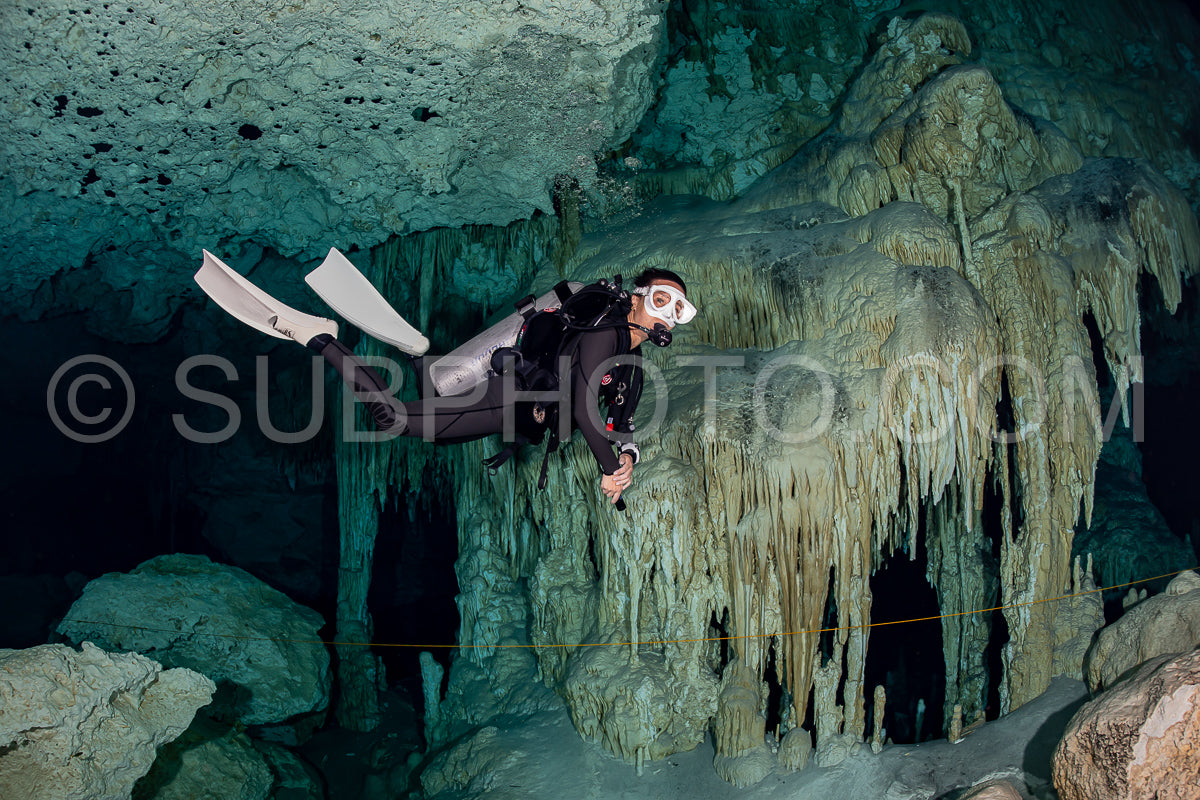 Photo de instructeur de plongée spéléo dirigeant un groupe de plongeurs dans un cenote mexicain sous l'eau