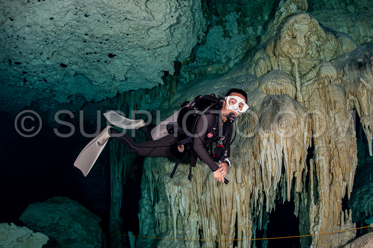 Photo de instructeur de plongée spéléo dirigeant un groupe de plongeurs dans un cenote mexicain sous l'eau