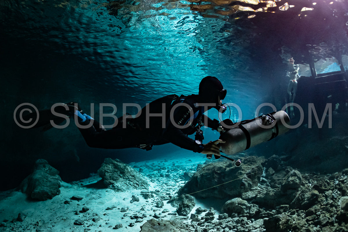 Photo de instructeur de plongée spéléo dirigeant un groupe de plongeurs dans un cenote mexicain sous l'eau