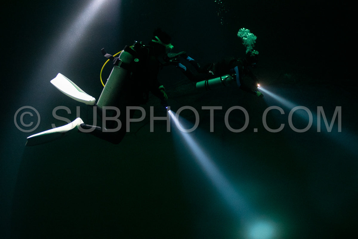 cave diver instructor leading a group of divers in a mexican cenote underwater