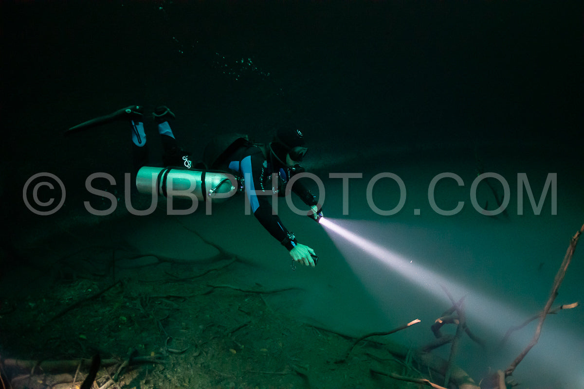 cave diver instructor leading a group of divers in a mexican cenote underwater