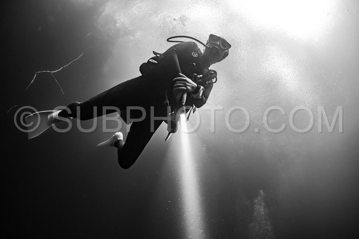 cave diver instructor leading a group of divers in a mexican cenote underwater
