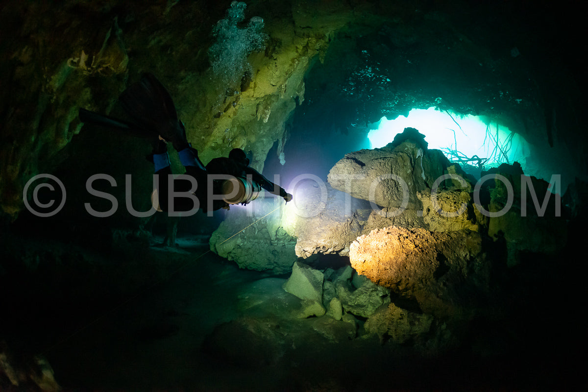cave diver instructor leading a group of divers in a mexican cenote underwater