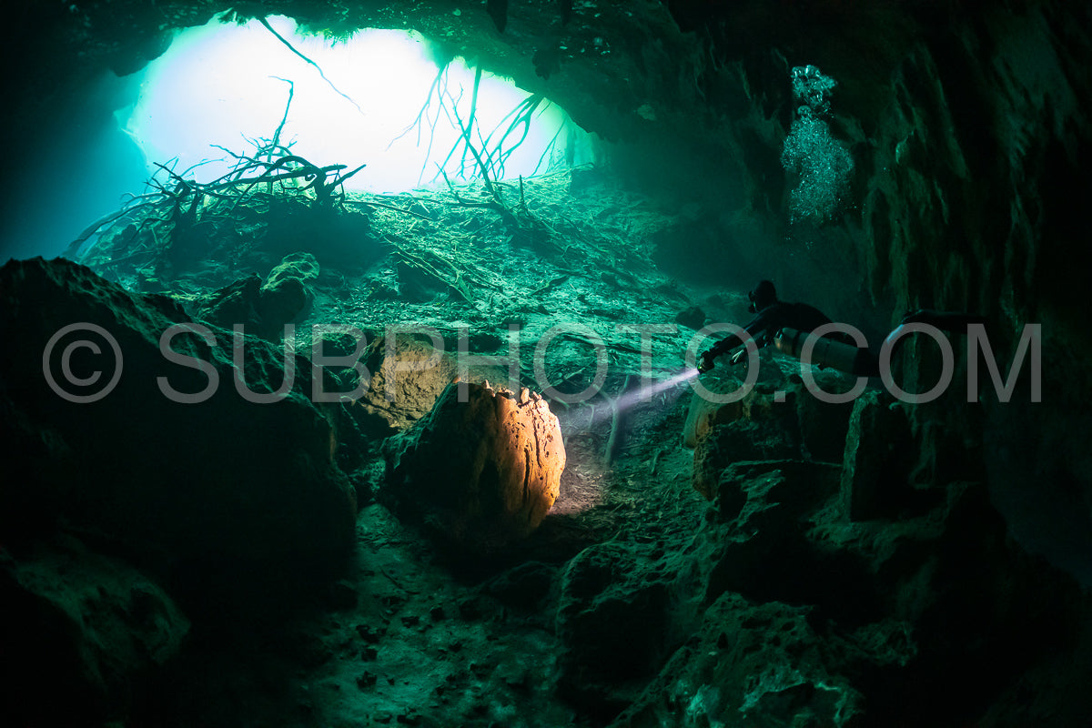 Photo de instructeur de plongée spéléo dirigeant un groupe de plongeurs dans un cenote mexicain sous l'eau