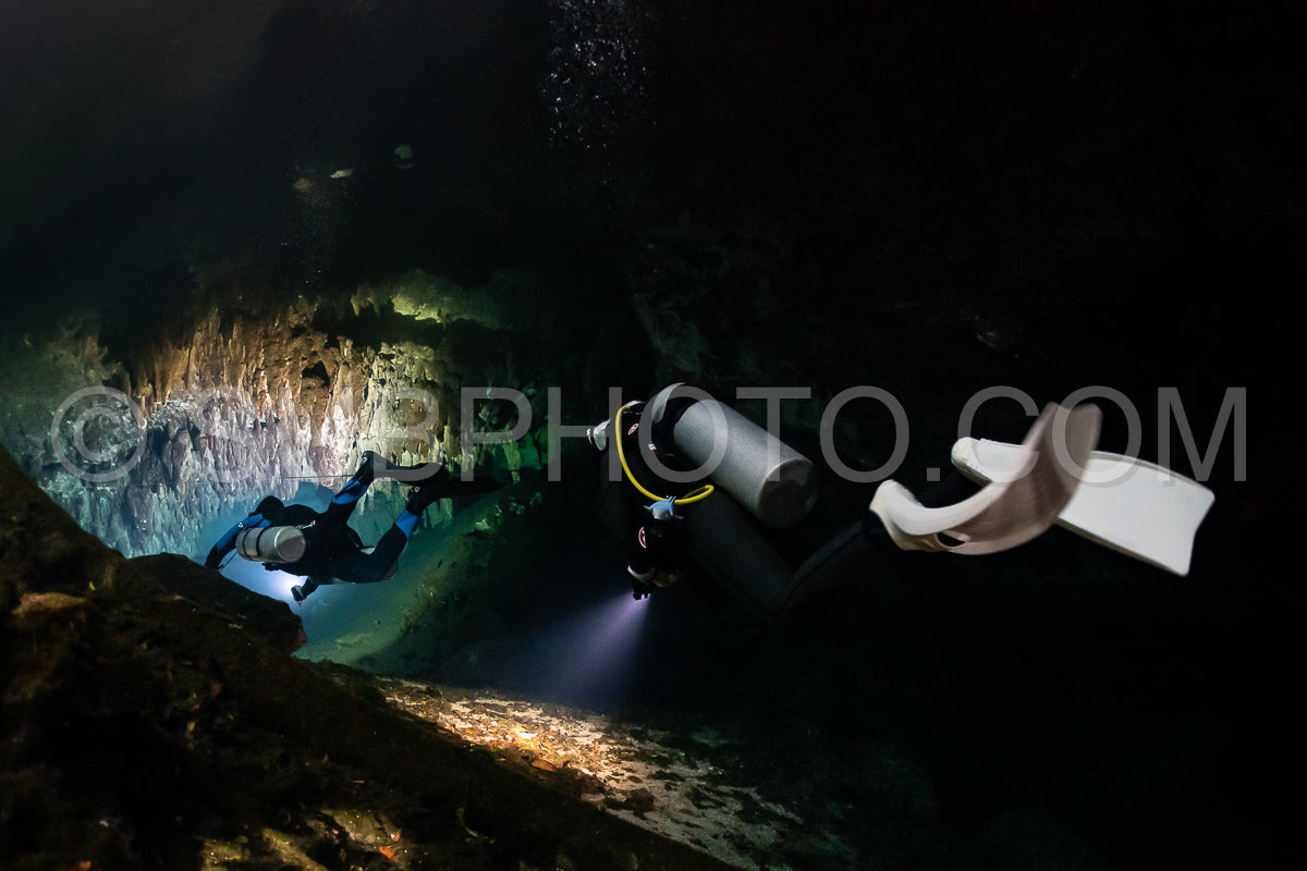 Photo de instructeur de plongée spéléo dirigeant un groupe de plongeurs dans un cenote mexicain sous l'eau