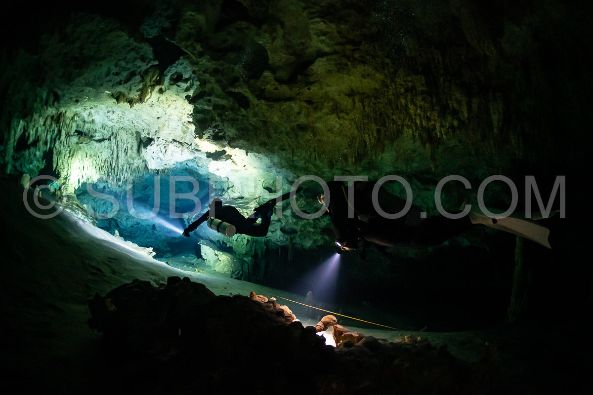 cave diver instructor leading a group of divers in a mexican cenote underwater
