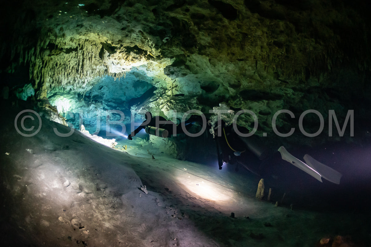 Photo de instructeur de plongée spéléo dirigeant un groupe de plongeurs dans un cenote mexicain sous l'eau