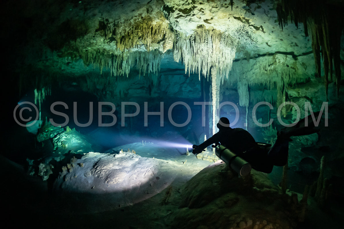 Photo de instructeur de plongée spéléo dirigeant un groupe de plongeurs dans un cenote mexicain sous l'eau