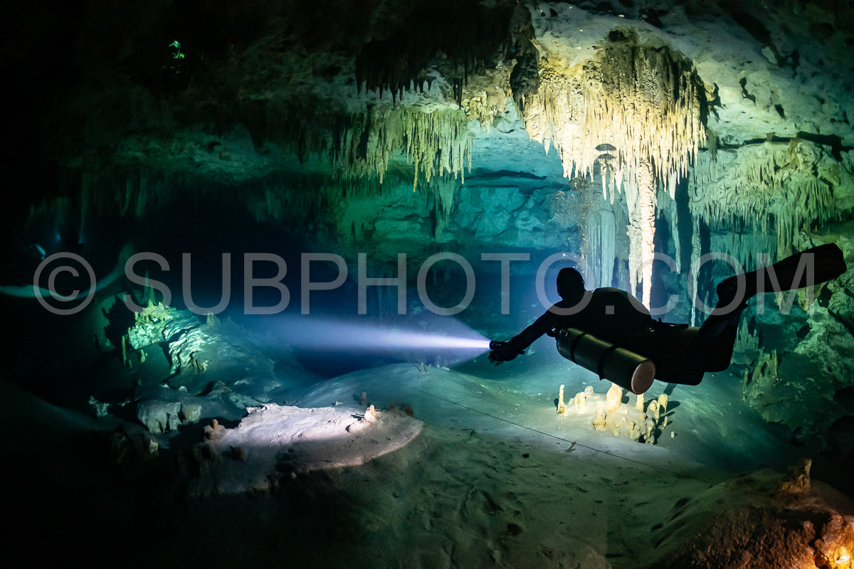 Photo de instructeur de plongée spéléo dirigeant un groupe de plongeurs dans un cenote mexicain sous l'eau