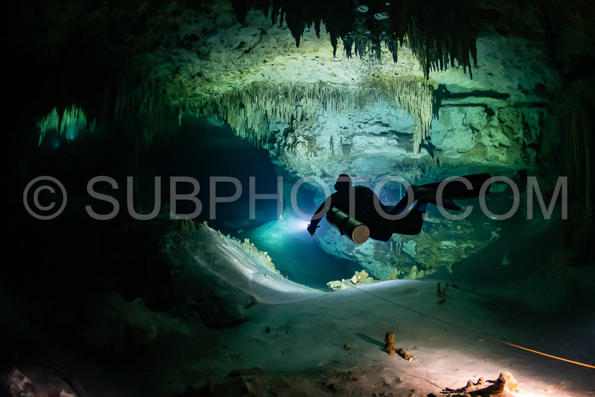 Photo de instructeur de plongée spéléo dirigeant un groupe de plongeurs dans un cenote mexicain sous l'eau