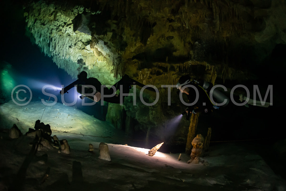 Photo de instructeur de plongée spéléo dirigeant un groupe de plongeurs dans un cenote mexicain sous l'eau