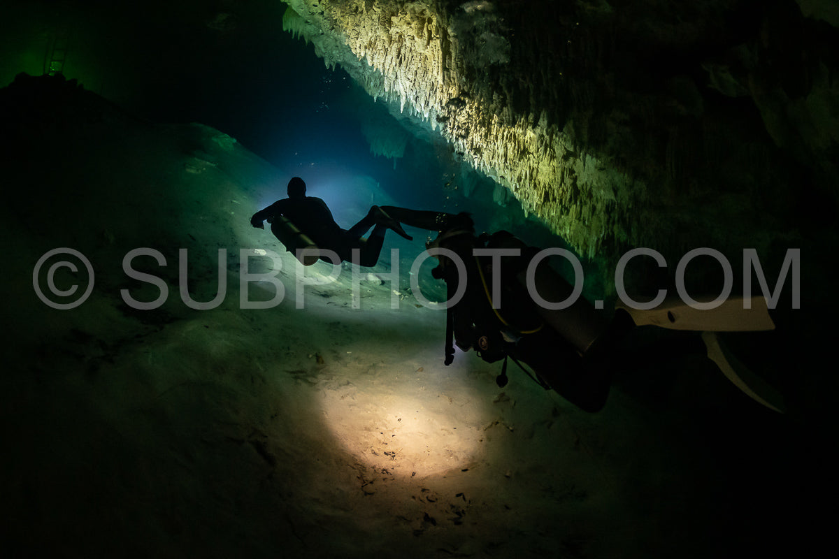 Photo de instructeur de plongée spéléo dirigeant un groupe de plongeurs dans un cenote mexicain sous l'eau