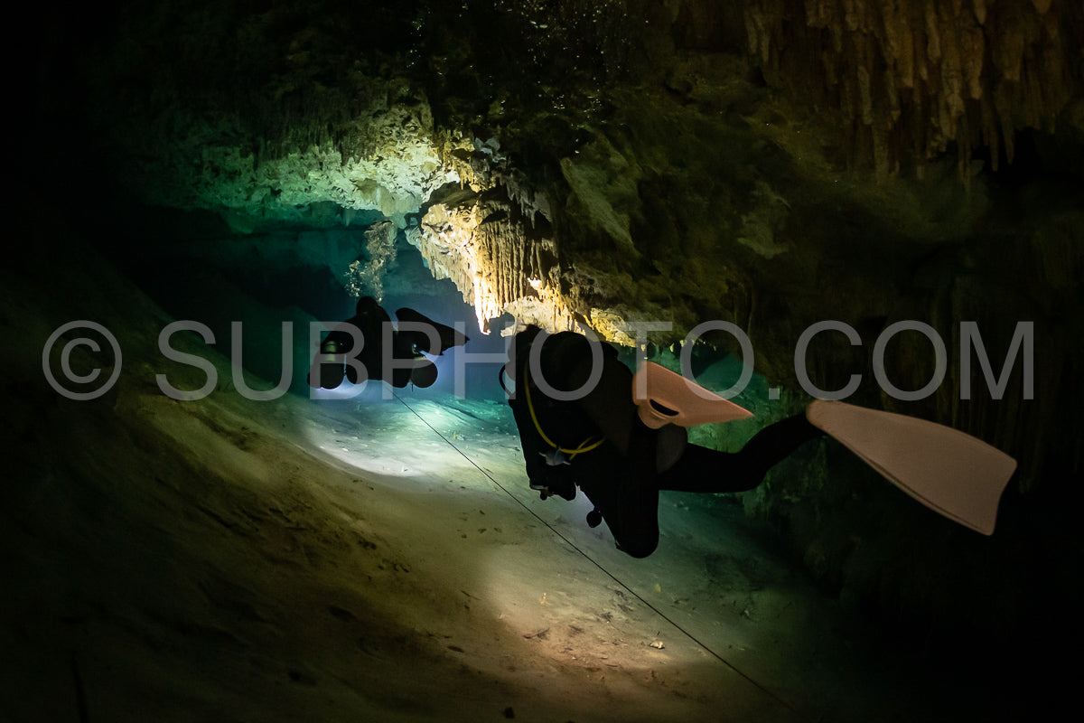 Photo de instructeur de plongée spéléo dirigeant un groupe de plongeurs dans un cenote mexicain sous l'eau