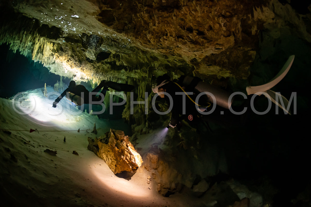 Photo de instructeur de plongée spéléo dirigeant un groupe de plongeurs dans un cenote mexicain sous l'eau