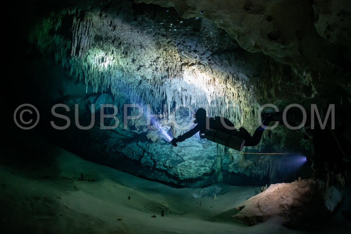 cave diver instructor leading a group of divers in a mexican cenote underwater