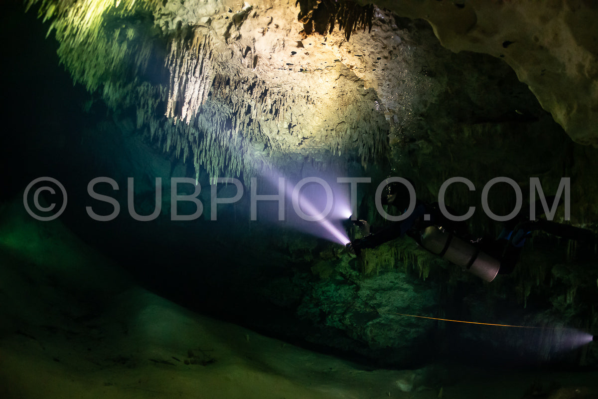 Photo de instructeur de plongée spéléo dirigeant un groupe de plongeurs dans un cenote mexicain sous l'eau