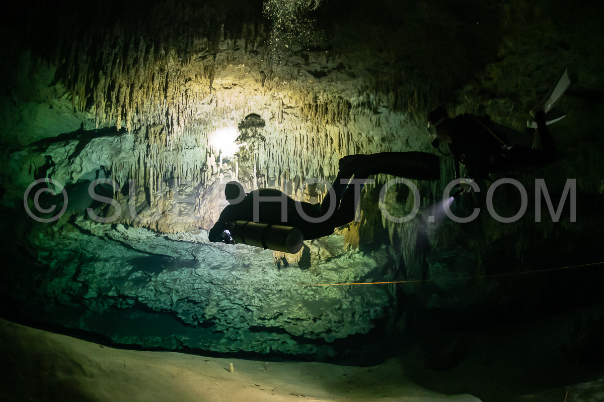 cave diver instructor leading a group of divers in a mexican cenote underwater