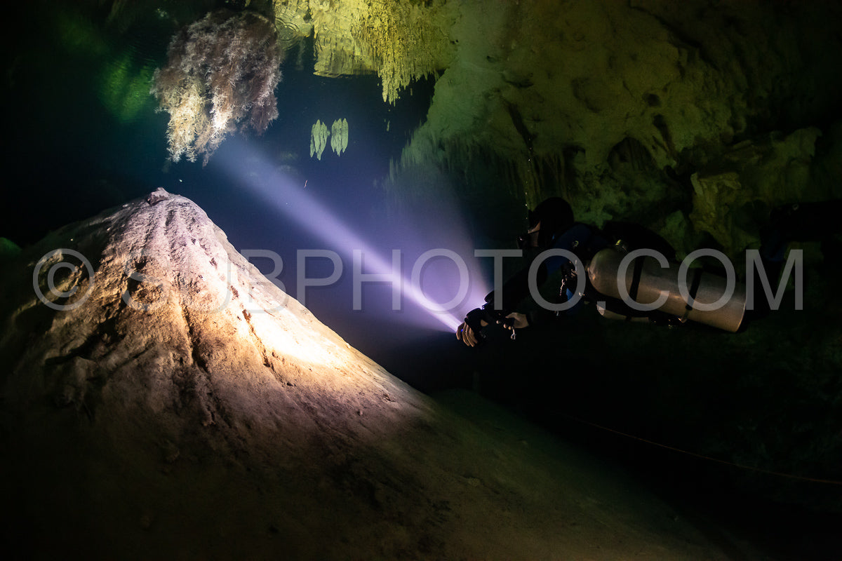 cave diver instructor leading a group of divers in a mexican cenote underwater
