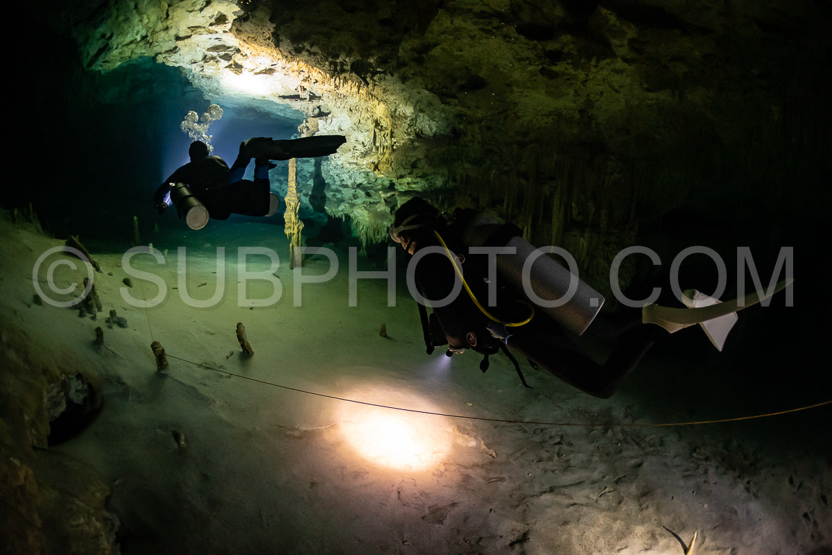 Photo de instructeur de plongée spéléo dirigeant un groupe de plongeurs dans un cenote mexicain sous l'eau