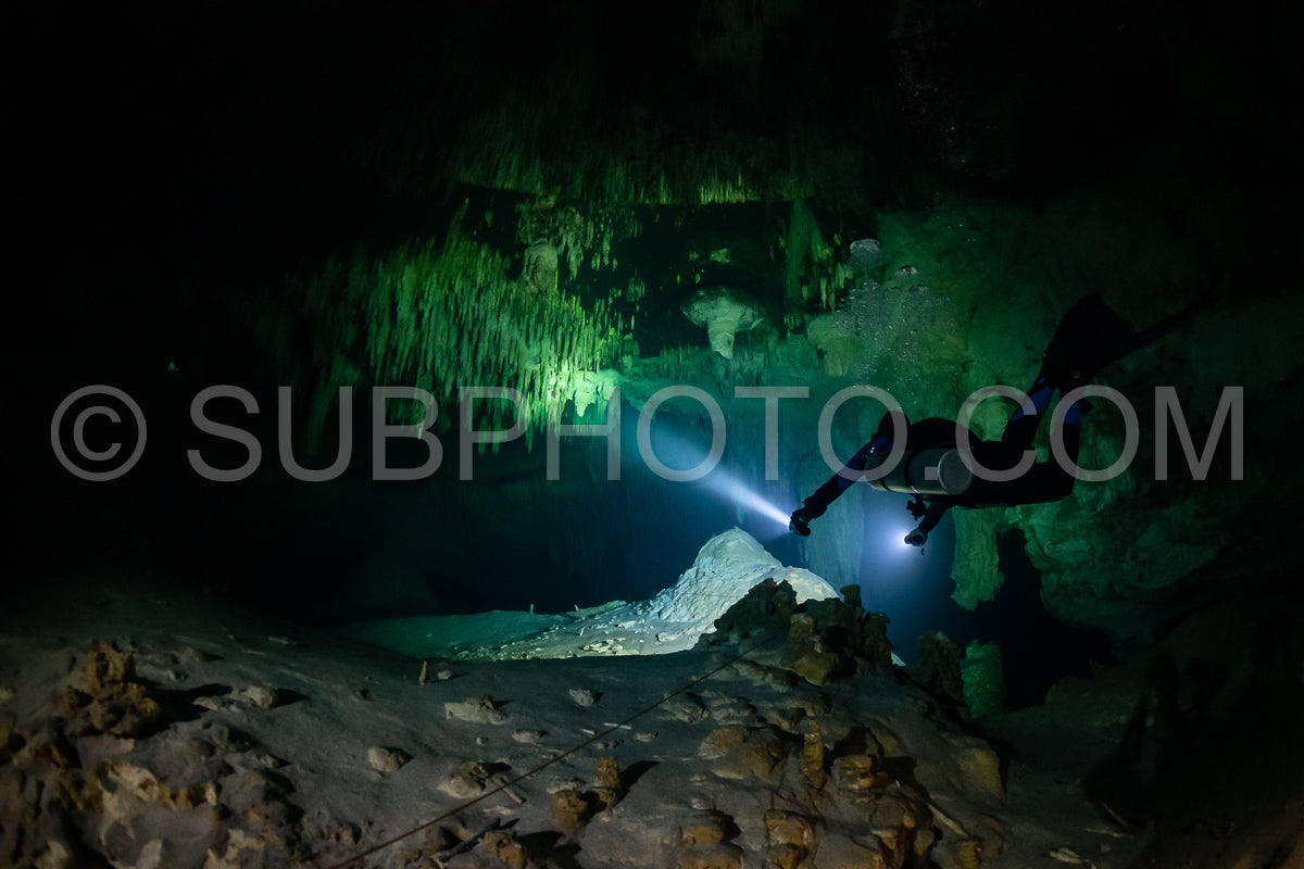 cave diver instructor leading a group of divers in a mexican cenote underwater