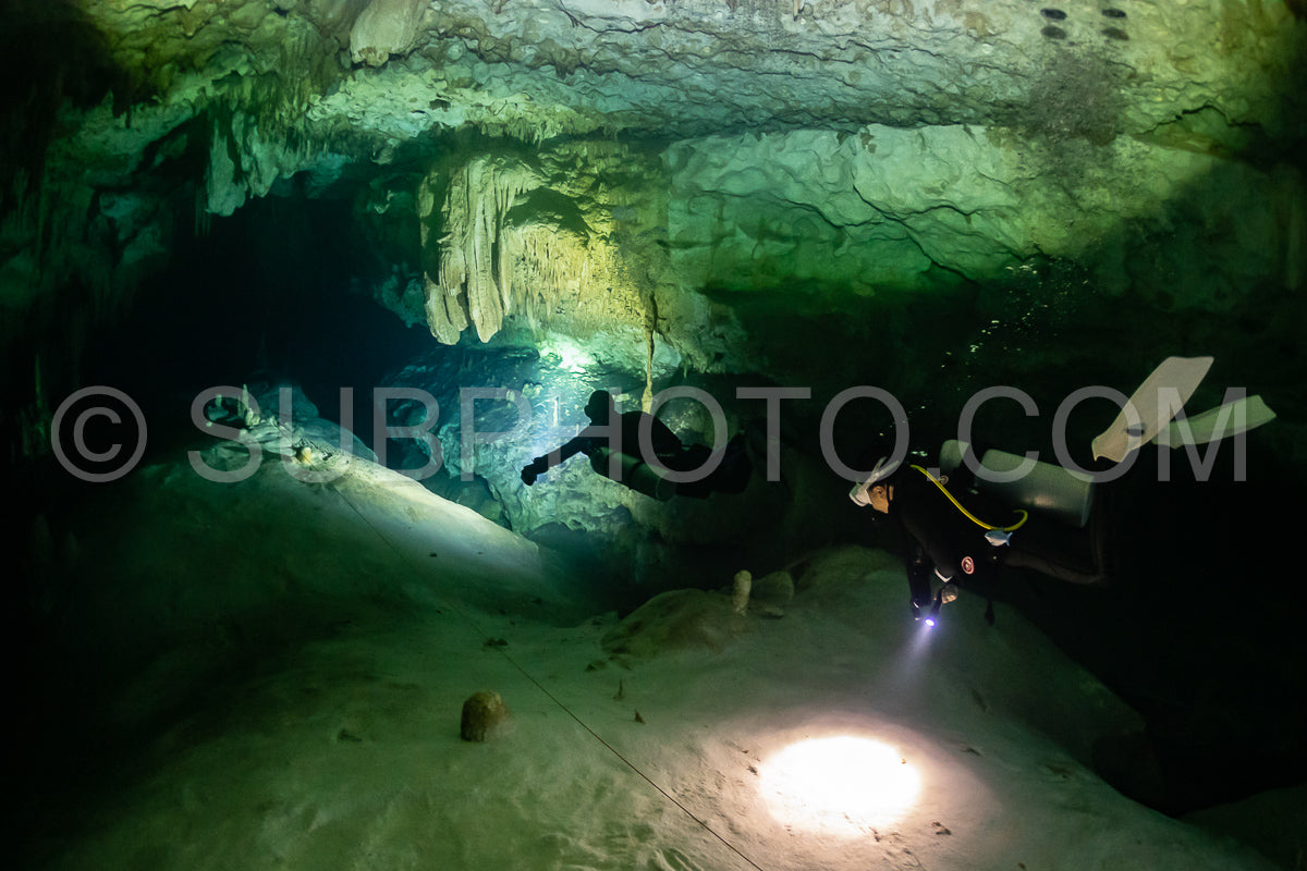 cave diver instructor leading a group of divers in a mexican cenote underwater
