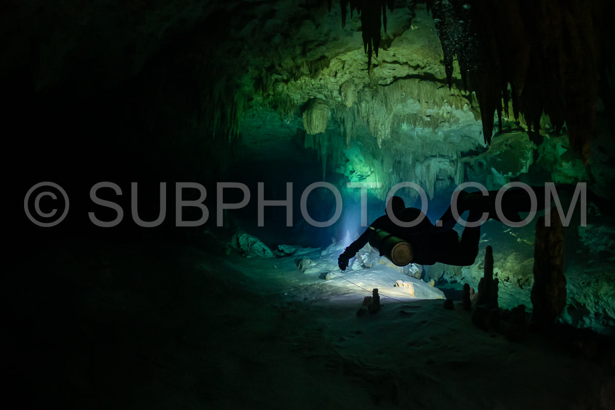 cave diver instructor leading a group of divers in a mexican cenote underwater