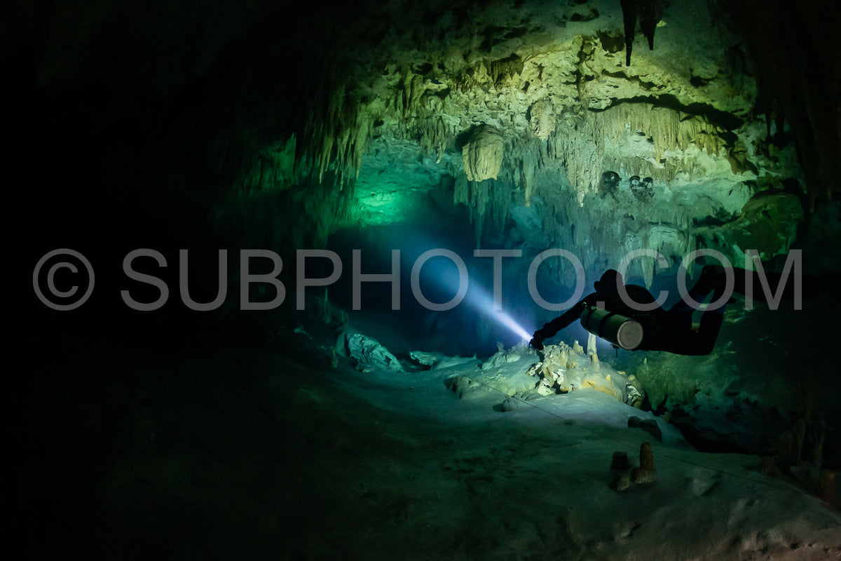 cave diver instructor leading a group of divers in a mexican cenote underwater