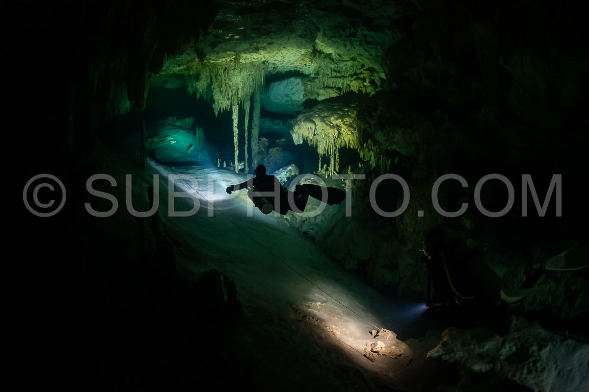 cave diver instructor leading a group of divers in a mexican cenote underwater
