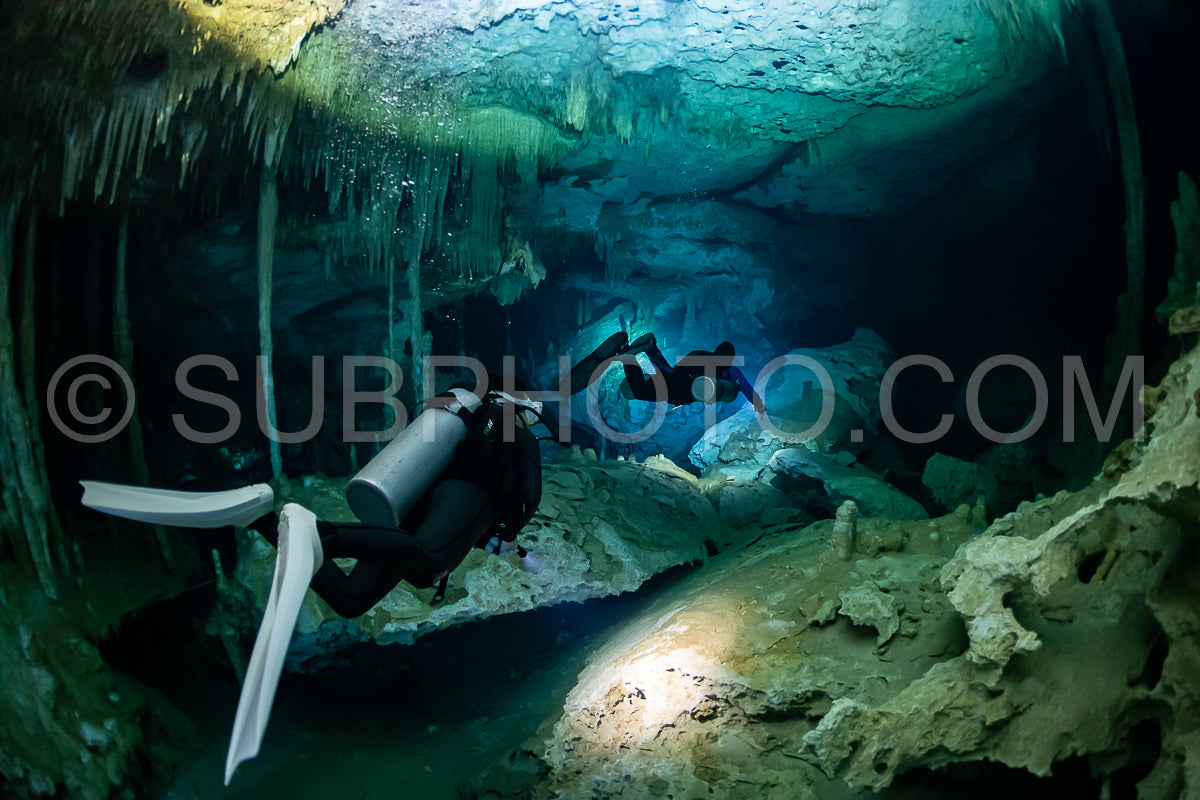 cave diver instructor leading a group of divers in a mexican cenote underwater
