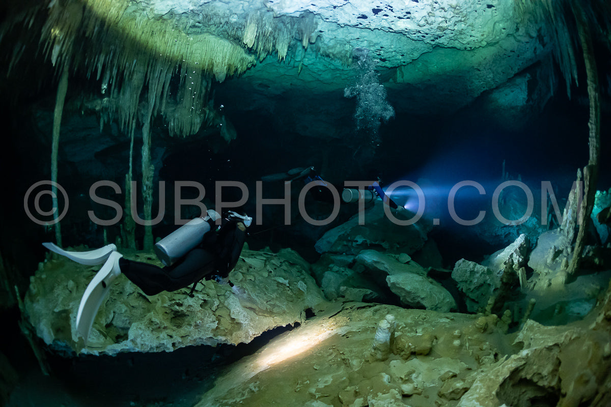 cave diver instructor leading a group of divers in a mexican cenote underwater
