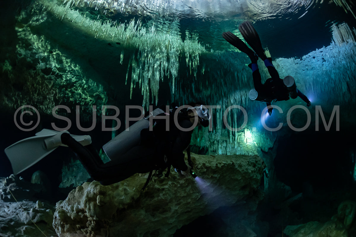Photo de instructeur de plongée spéléo dirigeant un groupe de plongeurs dans un cenote mexicain sous l'eau