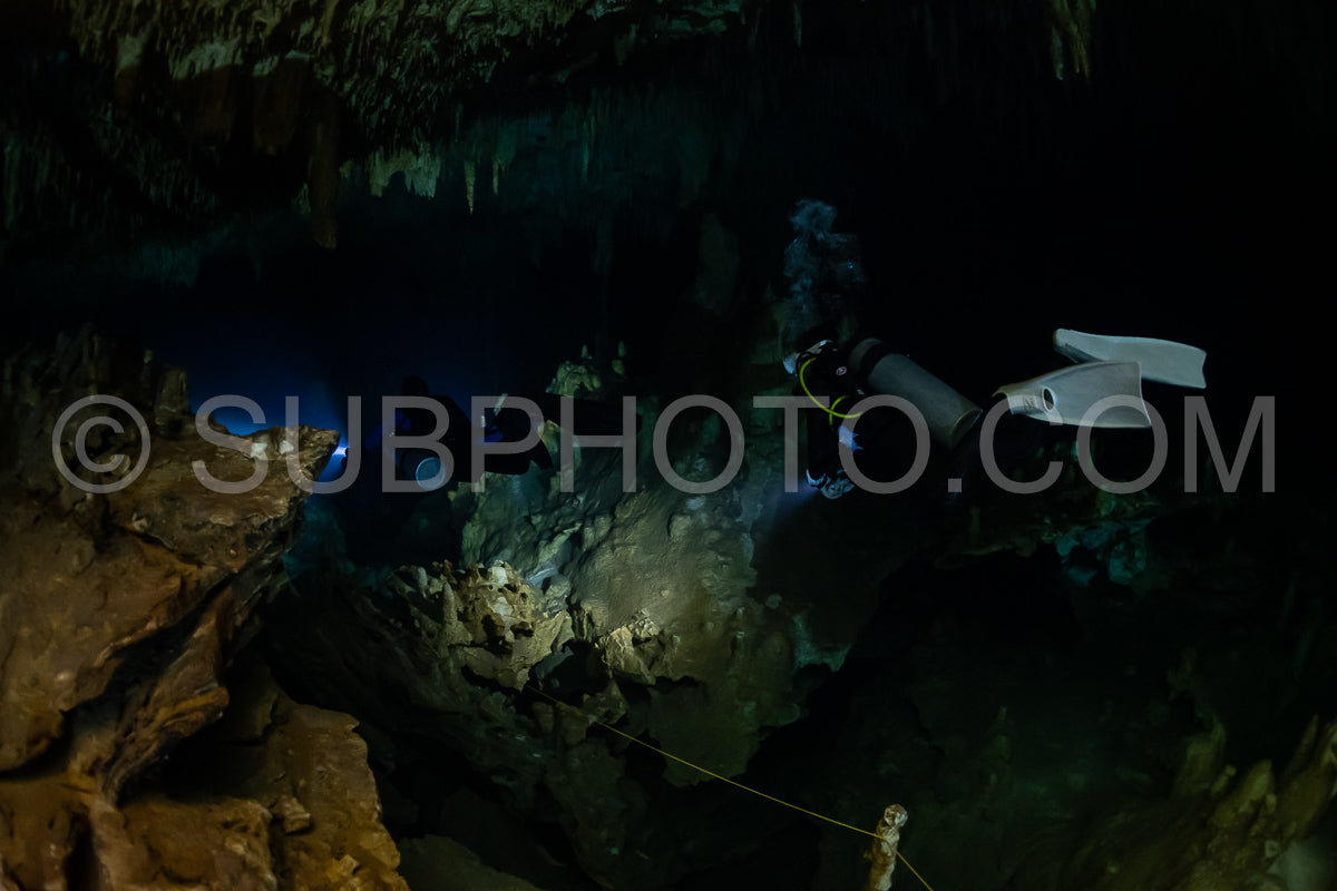 cave diver instructor leading a group of divers in a mexican cenote underwater