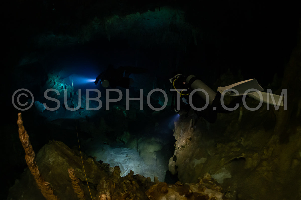 cave diver instructor leading a group of divers in a mexican cenote underwater