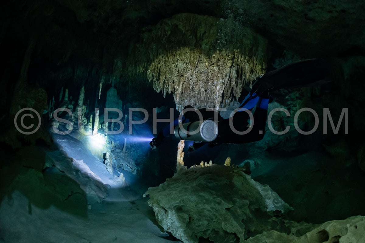 cave diver instructor leading a group of divers in a mexican cenote underwater