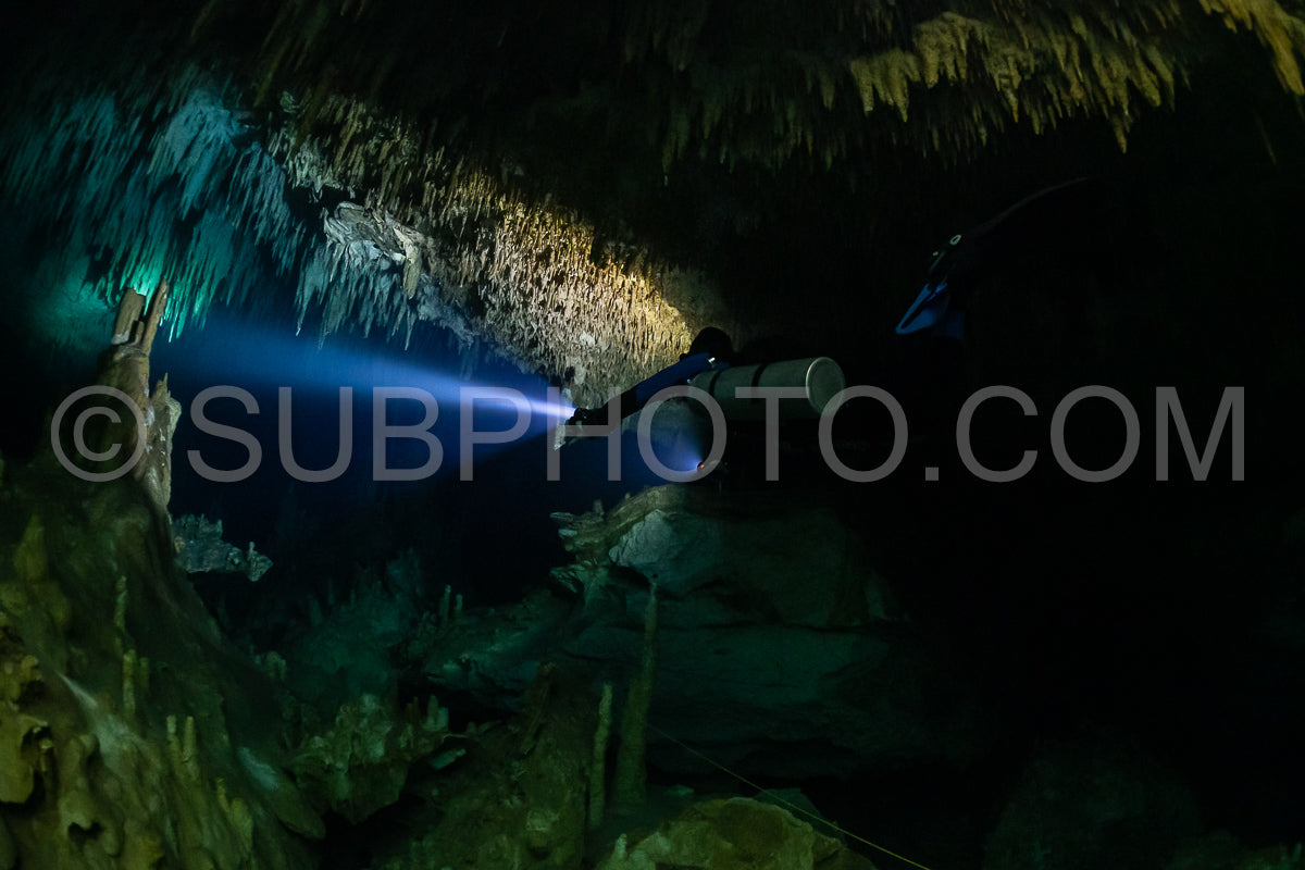cave diver instructor leading a group of divers in a mexican cenote underwater
