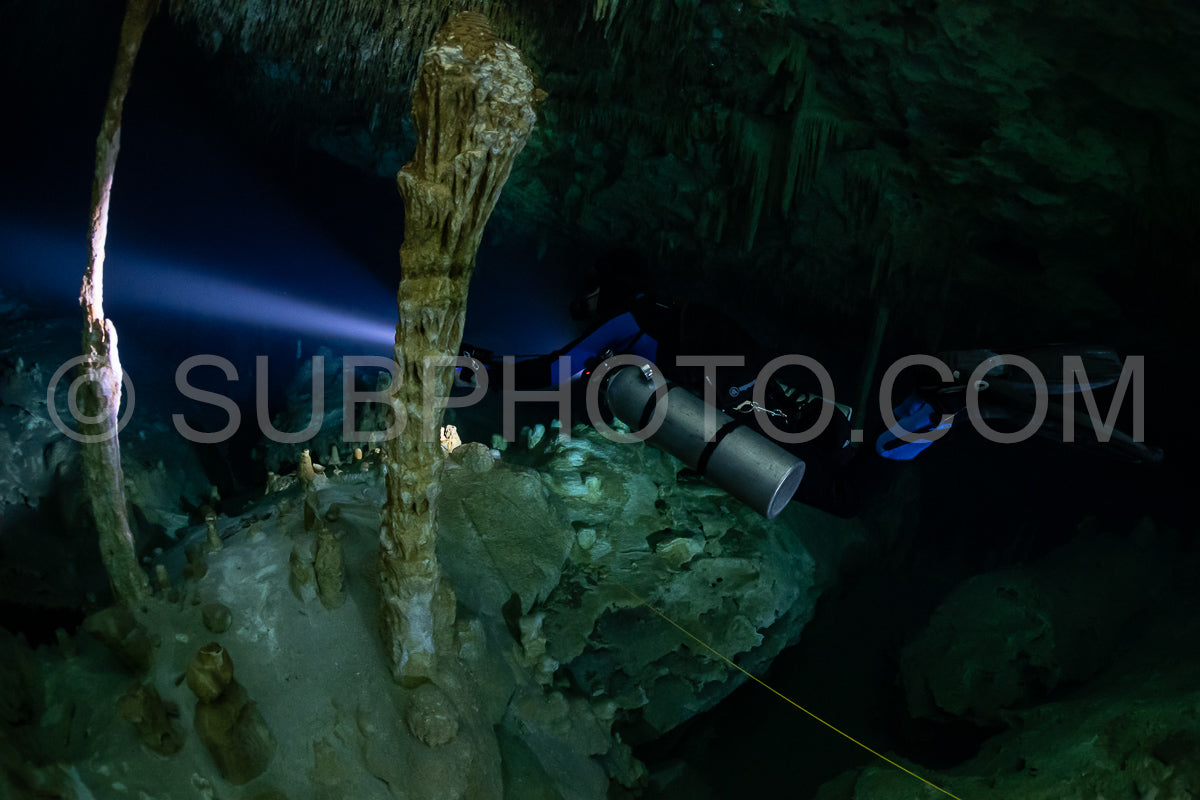 cave diver instructor leading a group of divers in a mexican cenote underwater